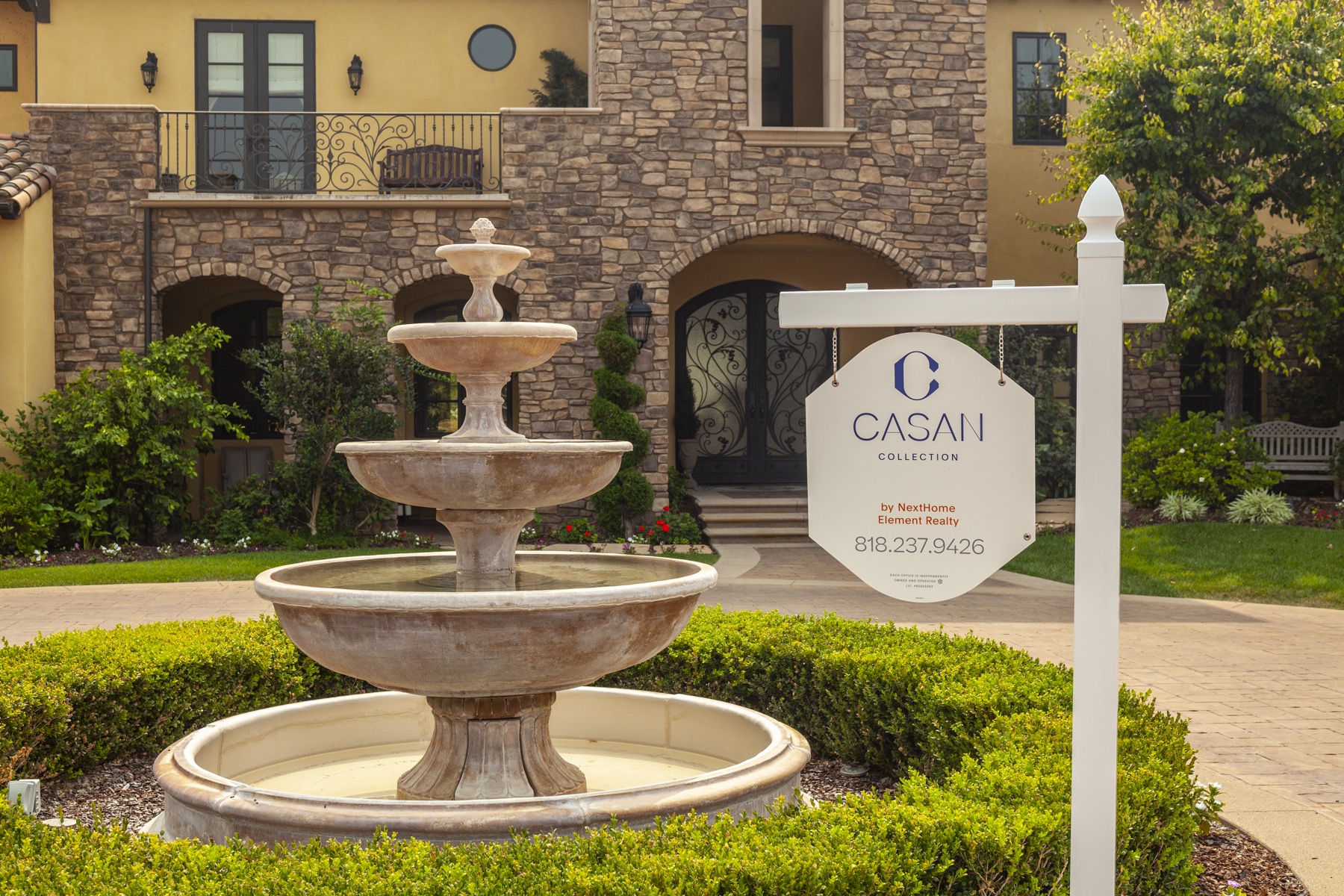 CASAN Collection sign beside a luxury home fountain